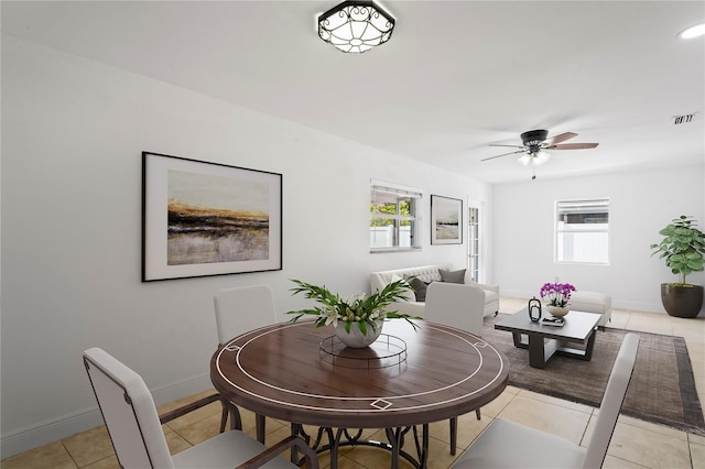 tiled dining area with a wealth of natural light and ceiling fan