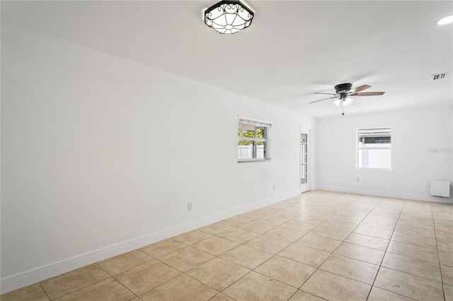 tiled spare room featuring ceiling fan and plenty of natural light