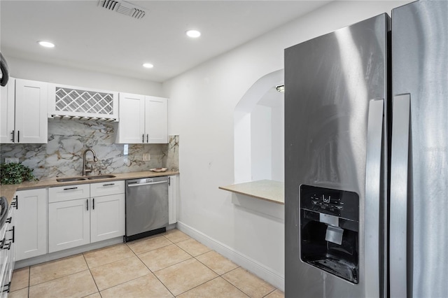 kitchen featuring white cabinets, stainless steel appliances, tasteful backsplash, and sink