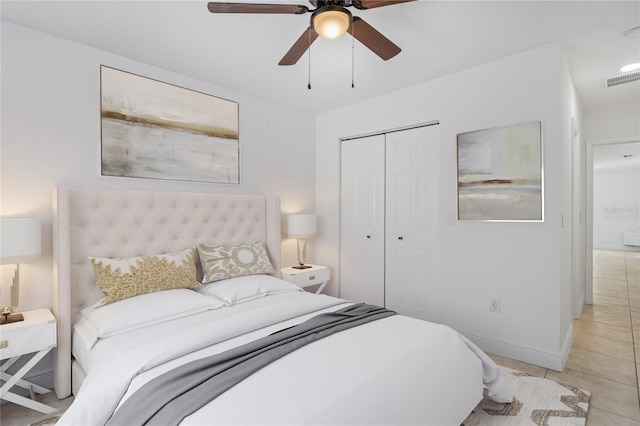 tiled bedroom with ceiling fan and a closet