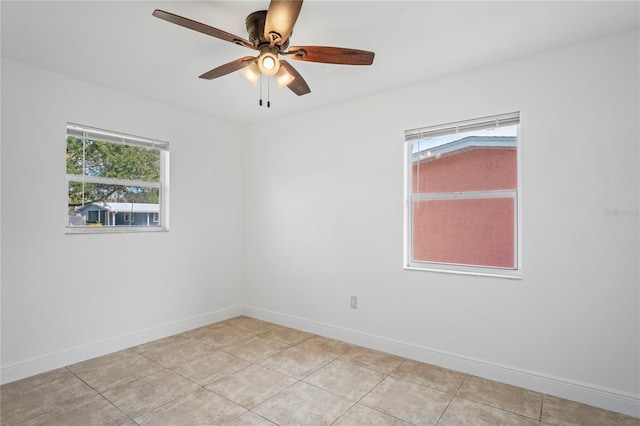 tiled empty room featuring plenty of natural light and ceiling fan