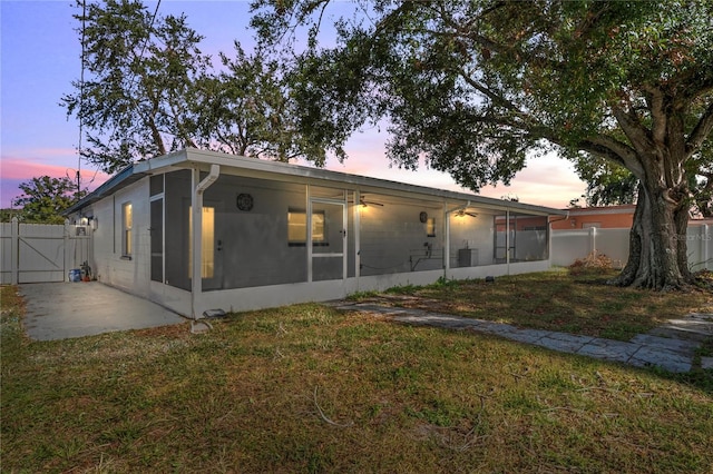 back house at dusk featuring a yard