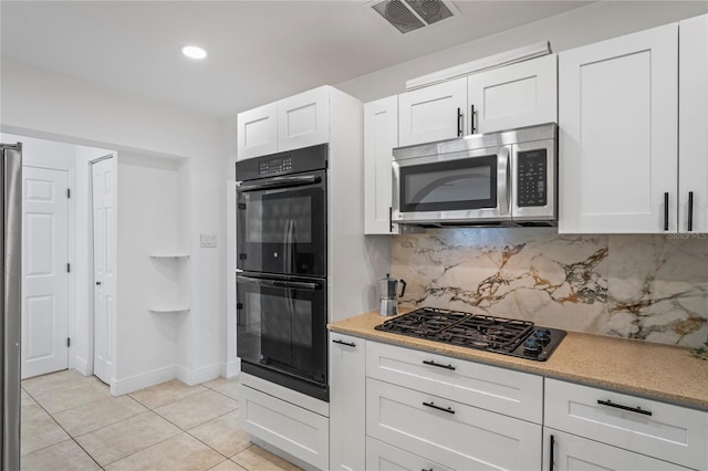 kitchen featuring decorative backsplash, white cabinets, black appliances, and light tile patterned floors