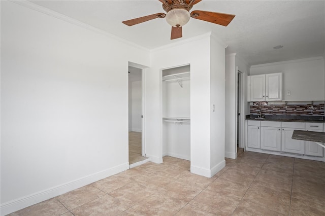 unfurnished bedroom with light tile patterned floors, a closet, ceiling fan, and crown molding