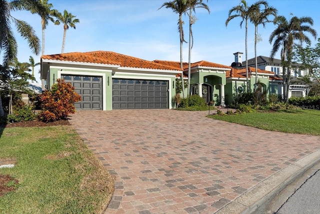 mediterranean / spanish home with a front yard and a garage