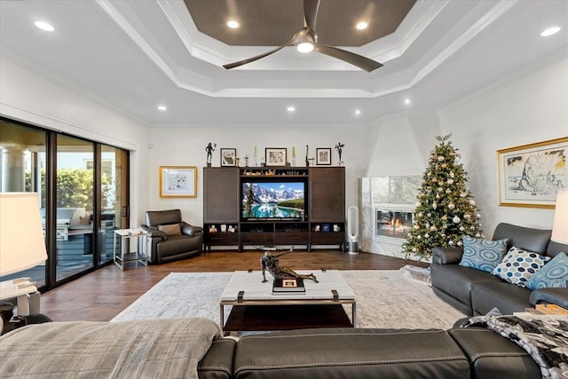 living room with dark hardwood / wood-style flooring, crown molding, a tile fireplace, and a tray ceiling