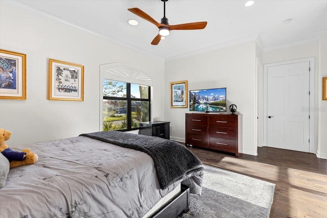 bedroom with dark hardwood / wood-style flooring, ceiling fan, and ornamental molding