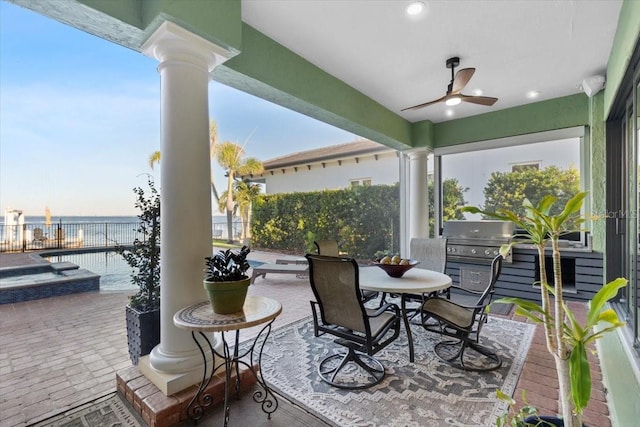 view of patio / terrace with ceiling fan, a water view, and grilling area