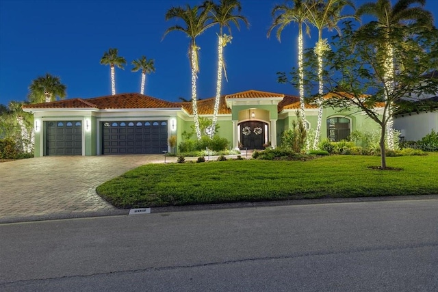 mediterranean / spanish-style house with a yard and a garage