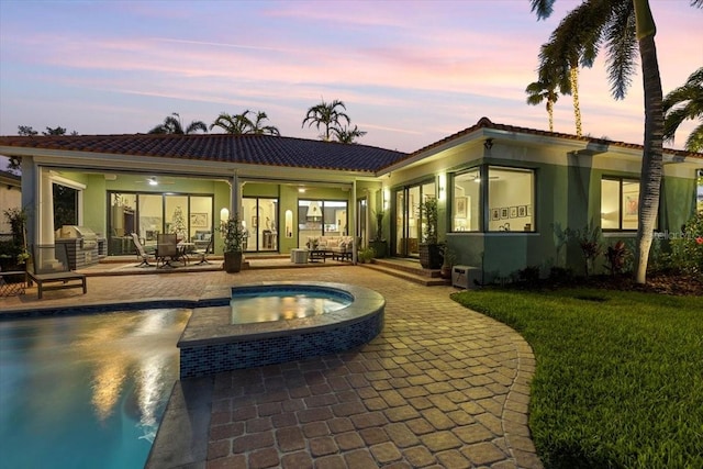 back house at dusk with a patio