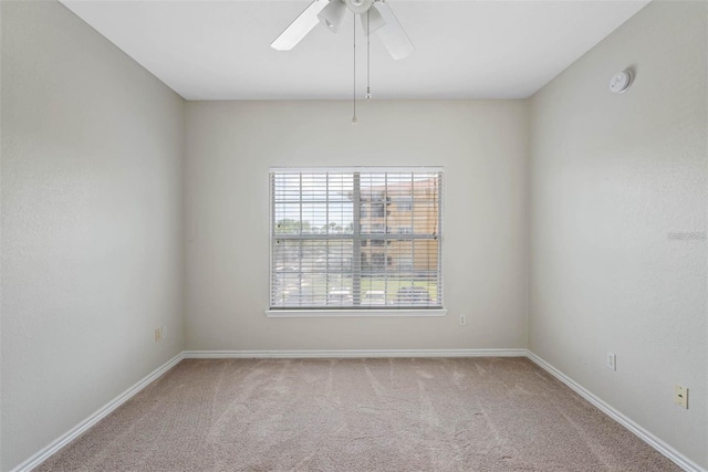 carpeted empty room featuring ceiling fan