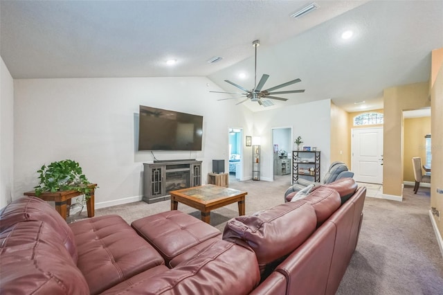 carpeted living room with a textured ceiling, ceiling fan, a fireplace, and vaulted ceiling