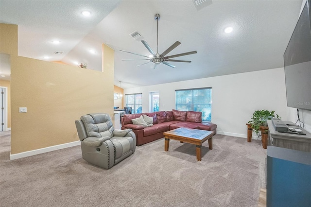 living room featuring a textured ceiling, light colored carpet, vaulted ceiling, and ceiling fan