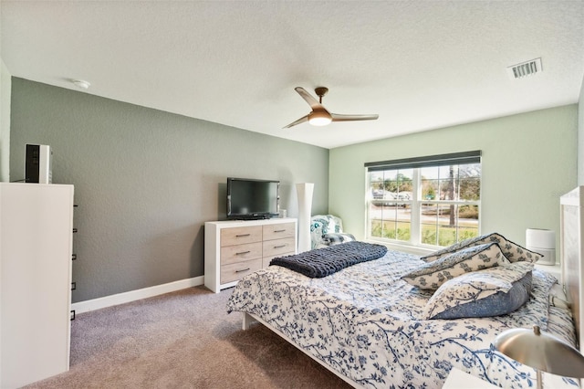 bedroom featuring ceiling fan, light colored carpet, and a textured ceiling