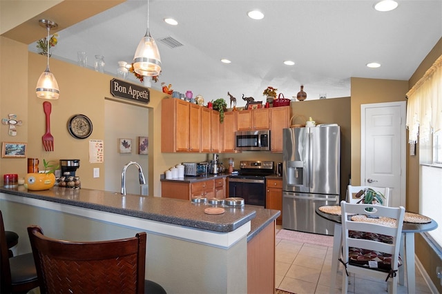 kitchen with sink, appliances with stainless steel finishes, decorative light fixtures, light tile patterned flooring, and kitchen peninsula