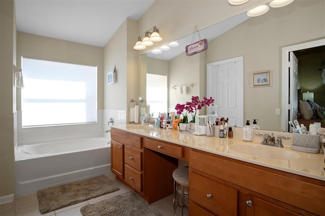 bathroom with tile patterned floors, a tub, and vanity