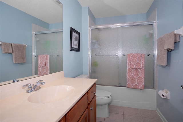 full bathroom featuring tile patterned floors, vanity, toilet, and enclosed tub / shower combo