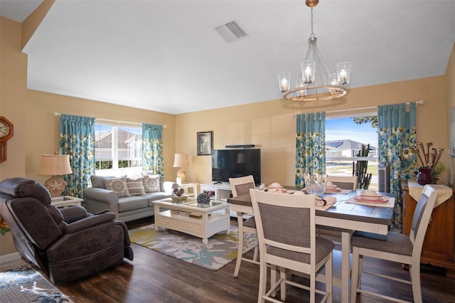 living room featuring plenty of natural light, dark hardwood / wood-style floors, and a notable chandelier