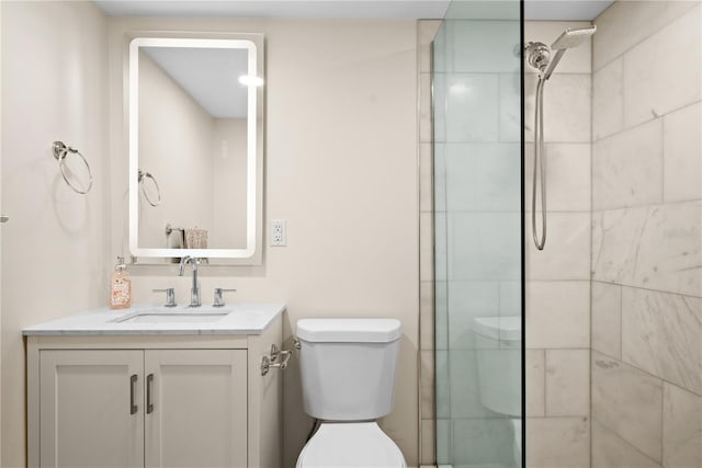 bathroom featuring vanity, toilet, and tiled shower