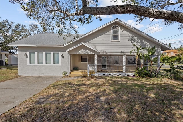 rear view of house with a yard, cooling unit, and a sunroom