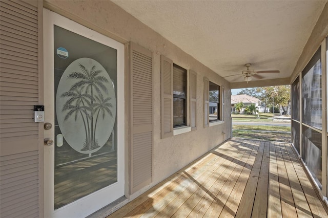 wooden deck featuring covered porch and ceiling fan