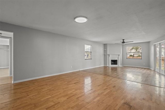 unfurnished living room featuring ceiling fan and light hardwood / wood-style flooring