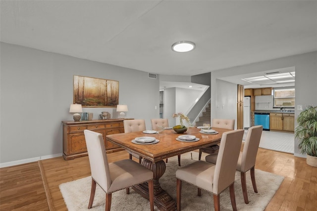 dining area featuring light wood-type flooring and sink