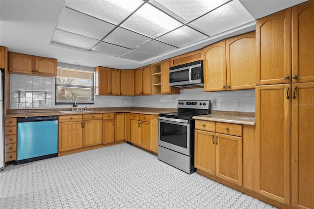 kitchen featuring sink, stainless steel appliances, and a drop ceiling