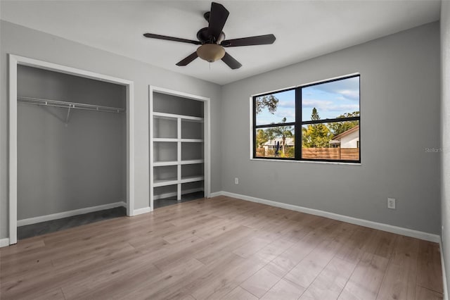 unfurnished bedroom with ceiling fan, light wood-type flooring, and a closet