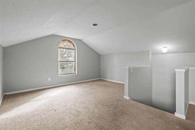 bonus room with carpet, a textured ceiling, and lofted ceiling