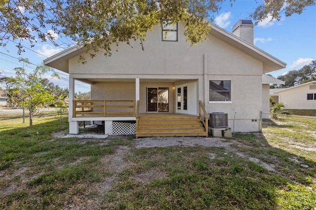 back of property featuring a lawn and central air condition unit