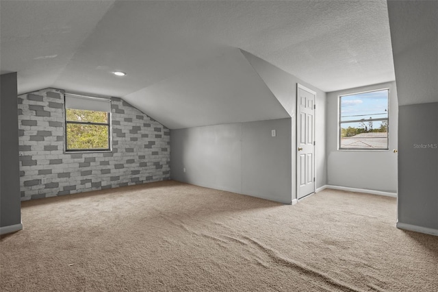 bonus room with a textured ceiling, carpet floors, and lofted ceiling