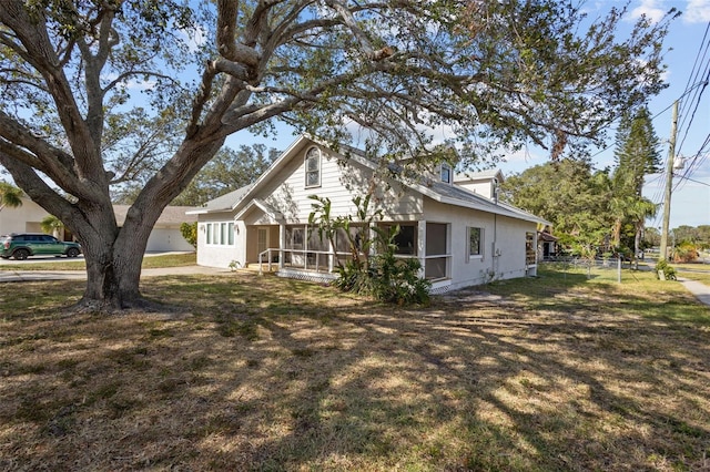 view of front of home with a front yard and a sunroom