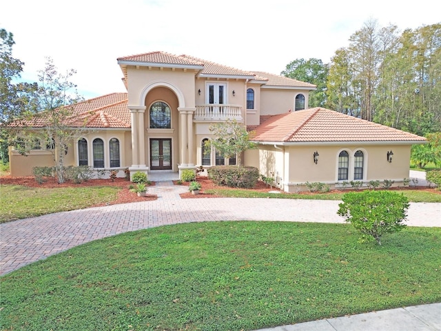 mediterranean / spanish-style home with french doors and a front yard