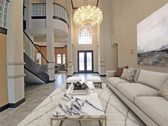 living room with french doors, a high ceiling, and a notable chandelier