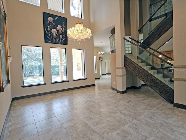 entryway with a towering ceiling, tile patterned floors, and a notable chandelier