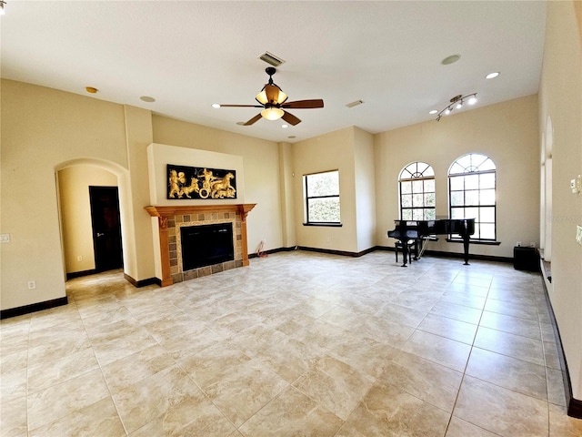 unfurnished living room featuring ceiling fan and a fireplace