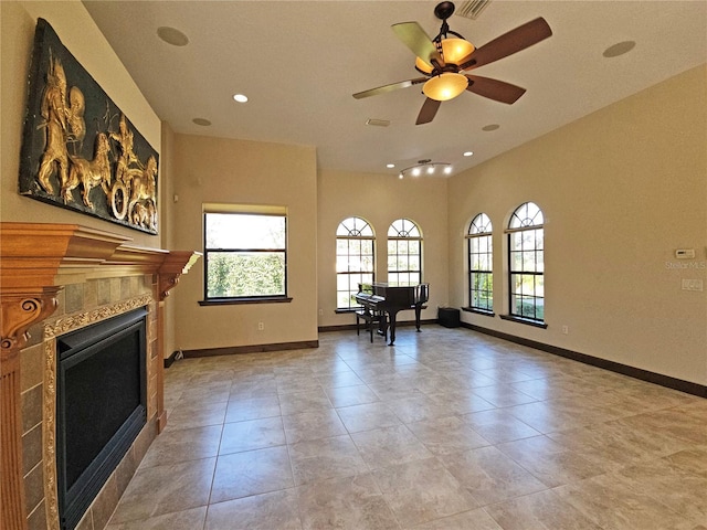 unfurnished living room featuring a tile fireplace, ceiling fan, and light tile patterned flooring