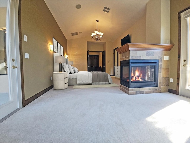 carpeted bedroom with a fireplace, vaulted ceiling, and an inviting chandelier