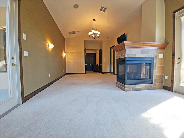 unfurnished living room featuring carpet floors, lofted ceiling, a fireplace, and an inviting chandelier