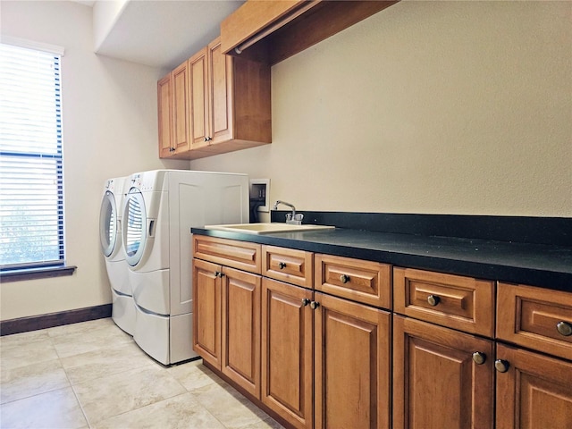 laundry area featuring light tile patterned flooring, cabinets, sink, and washing machine and clothes dryer