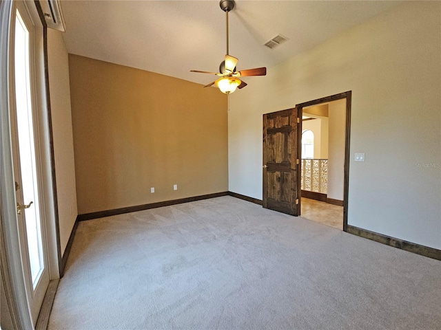 unfurnished bedroom featuring ceiling fan, light colored carpet, and vaulted ceiling