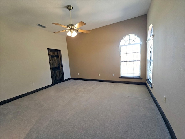 carpeted spare room featuring ceiling fan