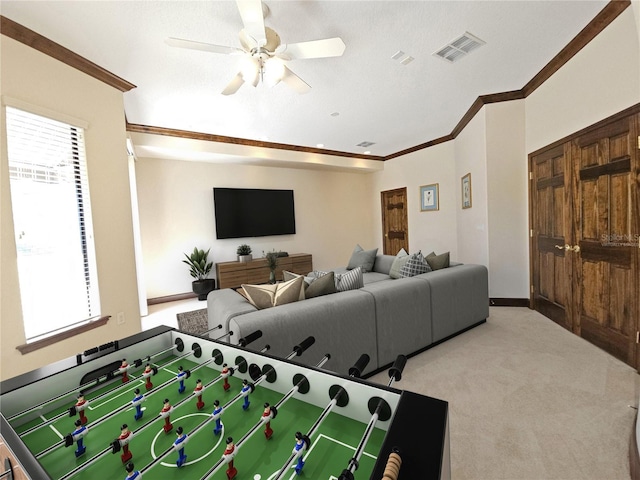 rec room with ceiling fan, ornamental molding, and light carpet