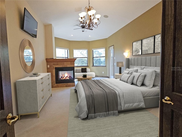 carpeted bedroom with a tile fireplace and an inviting chandelier