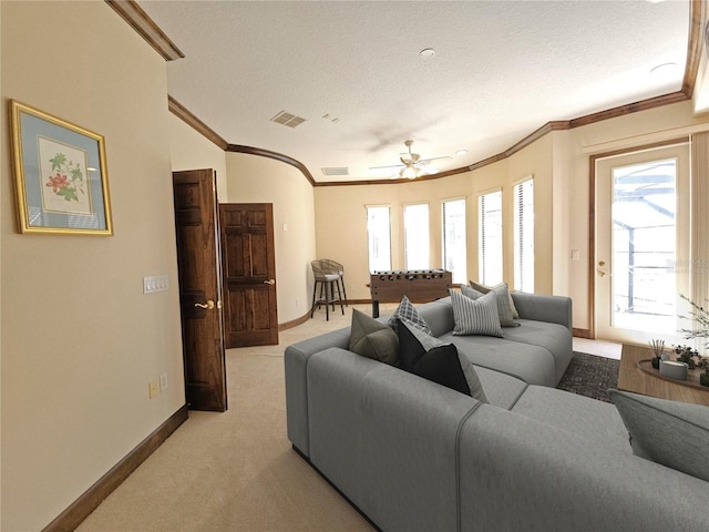 carpeted living room with ceiling fan, a textured ceiling, and ornamental molding