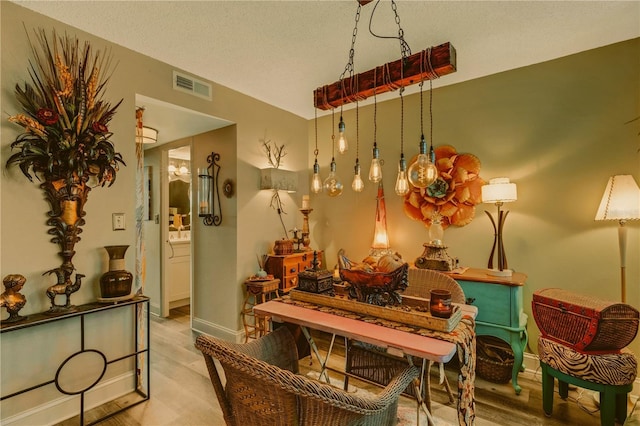 dining space with light hardwood / wood-style floors and a textured ceiling