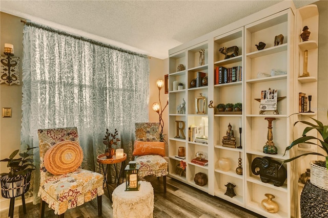 living area featuring a textured ceiling and hardwood / wood-style flooring