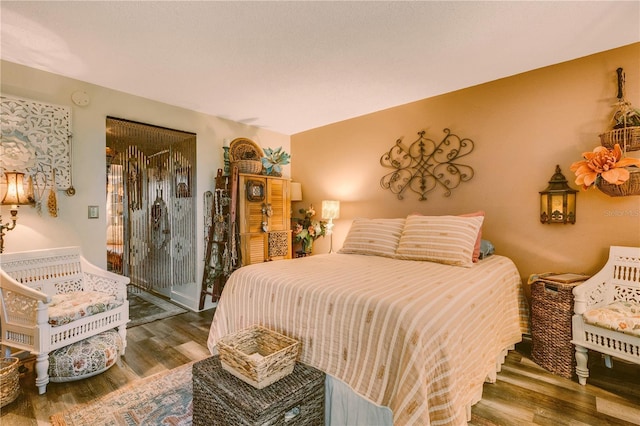 bedroom featuring wood-type flooring and access to outside