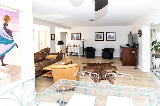 living room featuring light hardwood / wood-style flooring and ceiling fan